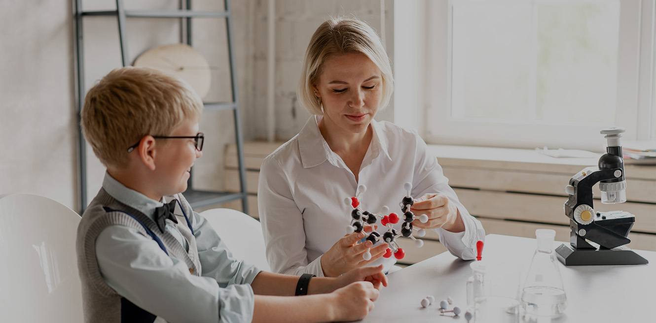 Female science tutor in Long Island studying chemistry with student